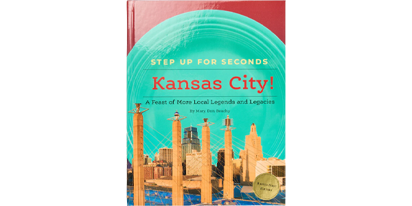 Cover of the book “Step Up for Seconds: Kansas City!” showing an illustrated Kansas City skyline with a teal circular design.