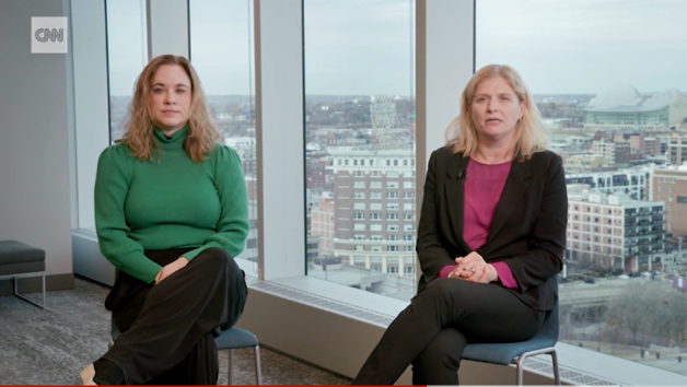 Dr. Jenna Miller and Dr. Jennifer Goldman sit in front of a window overlooking the Kansas City skyline.