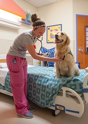 The nurse uses a stethoscope on Hope in the EMU at Children's Mercy.