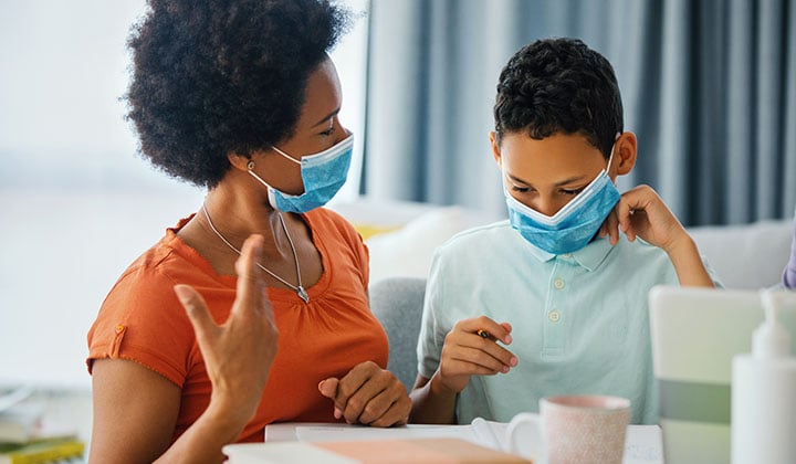 Mom showing son how to wear a face mask