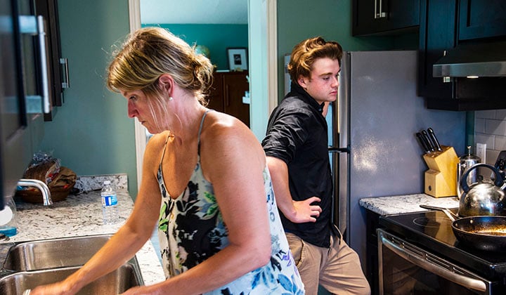 Teen and mom in kitchen cleaning